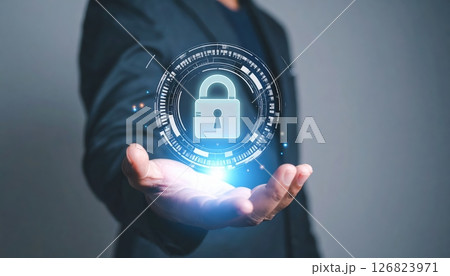 Modern digital security concept with a person holding a holographic lock symbol representing cybersecurity protection 126823971