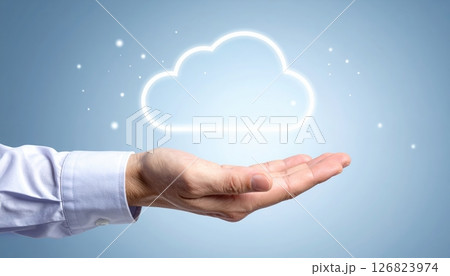 Digital cloud computing technology concept with glowing cloud icon over open hand in a futuristic setting 126823974