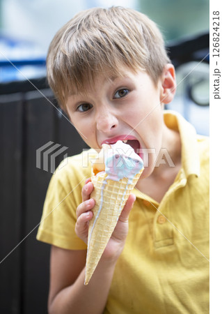 Happy little toddler boy eating colorful ice cream in summer, outdoors Happy little toddler boy eating colorful ice cream in summer, outdoors 126824218