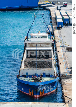 Cargo ship loaded with scrap metal docked at industrial port 126824667