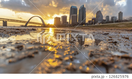 Golden Sunset over City Skyline Reflected in Muddy Water 126825976