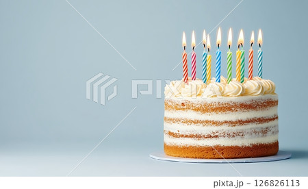 Layered Vanilla Birthday Cake with Colorful Candles on Light Blue Background 126826113