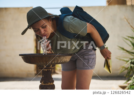 Traveler Drinking Water from a Fountain in Historic Village Outdoors Traveler Drinking Water from a Fountain in Historic Village Outdoors 126826542