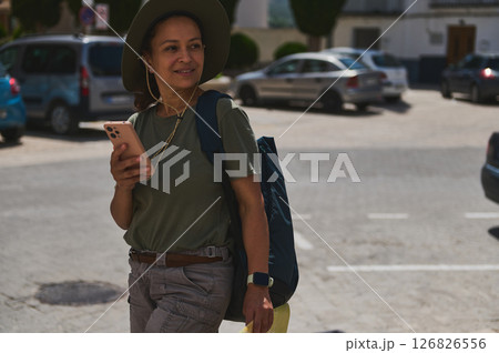 Traveler Exploring a Scenic Spanish Village Holding a Smartphone 126826556