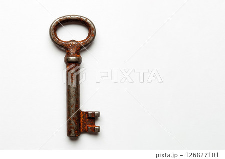 An old rusty key on a white background. Space for text. An old rusty key on a white background. Space for text. 126827101