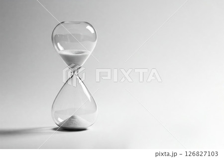 An hourglass on a white background symbolizes the passage of time. Space for text. 126827103