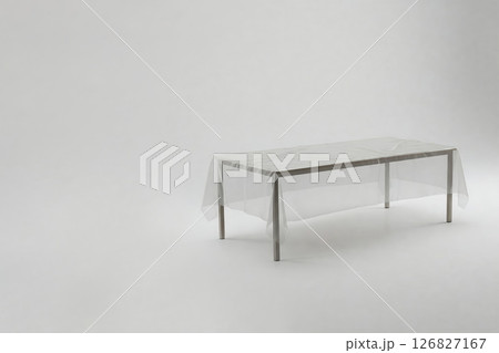 A table with a transparent tablecloth on a light background. Space for text. 126827167
