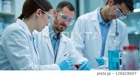 Dedicated scientists meticulously analyze samples, their focused gazes tracing intricate details under bright lab lights 126828607