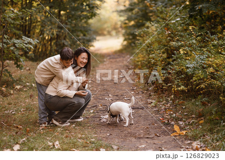 Mother and Son Laughing While Walking Dog in Forest Mother and Son Laughing While Walking Dog in Forest 126829023