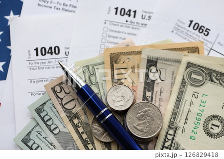 American US dollars money bills and coins with pen on IRS tax form blanks close up American US dollars money bills and coins with pen on IRS tax form blanks close up 126829418