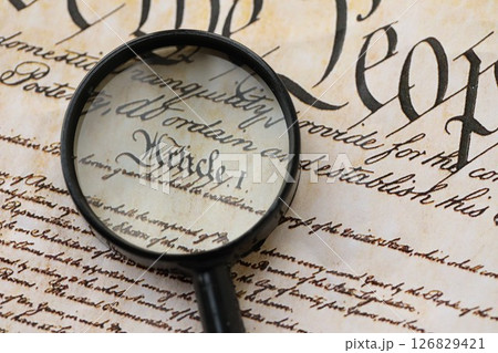 American USA Constitution paper page and magnifying glass close up 126829421