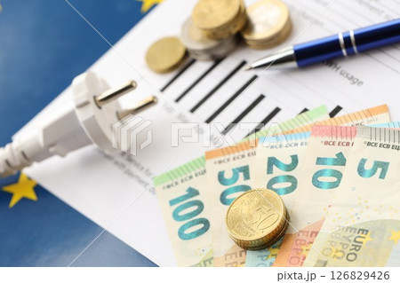 European union Euro money bills and coins with european electricity utility bill on table European union Euro money bills and coins with european electricity utility bill on table 126829426