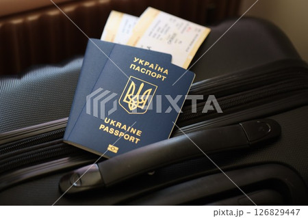 Ukrainian passports with tickets lies on touristic suitcase in airport hall 126829447