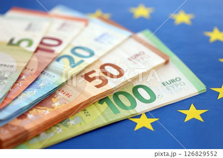 European eur currency money bills on Euro union blue flag close up 126829552