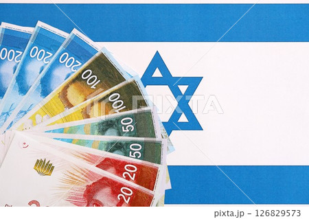Israel New Shekels banknotes on national flag. The current Israel money bills lies on flag 126829573