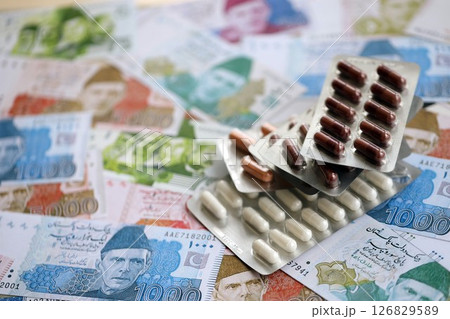Pakistan rupees banknotes and medicine pills. Pakistan money bills with drugs close up 126829589
