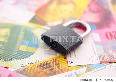 Swiss franc banknotes and padlock. The current francs money bills with lock lies in big amount 126829600