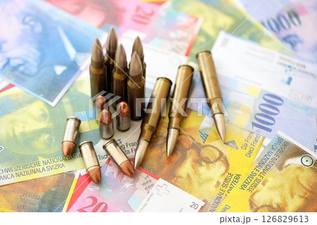 Swiss franc banknotes and bullets. The current francs money bills and ammo lies on table Swiss franc banknotes and bullets. The current francs money bills and ammo lies on table 126829613