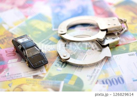 Swiss franc banknotes and toy car with handcuffs. The current francs money bills and car with cuffs Swiss franc banknotes and toy car with handcuffs. The current francs money bills and car with cuffs 126829614