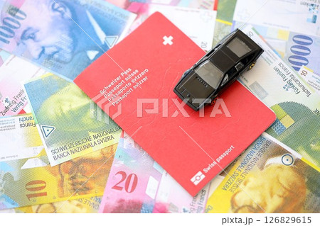 Swiss franc banknotes and toy car with passport. The current francs money bills and car with pass 126829615
