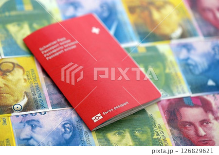 Swiss franc banknotes and passport. The current francs money bills and pass lies on table Swiss franc banknotes and passport. The current francs money bills and pass lies on table 126829621