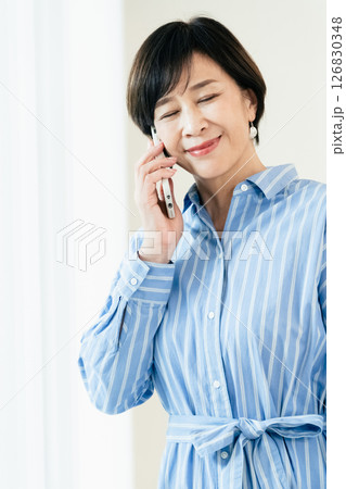 スマホで通話する中高年女性 スマホで通話する中高年女性 126830348