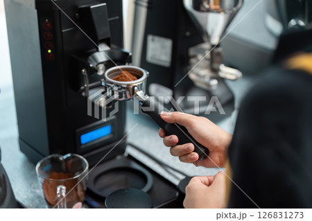 Coffee Grinding and Precision Measurement. A skilled barista measuring coffee grounds with precision. 126831273