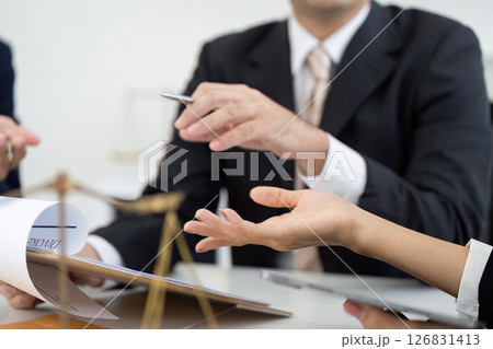 Lawyer Consultation and Legal Discussion. A lawyer engaging in a detailed consultation with clients, discussing legal matters and strategies. 126831413