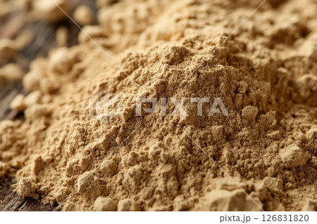 A pile of brown powder on a wooden surface 126831820