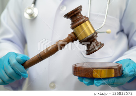 Doctor holding judge gavel, forensic medicine, medical law and crime justice concept. Doctor holding judge gavel, forensic medicine, medical law and crime justice concept. 126832572