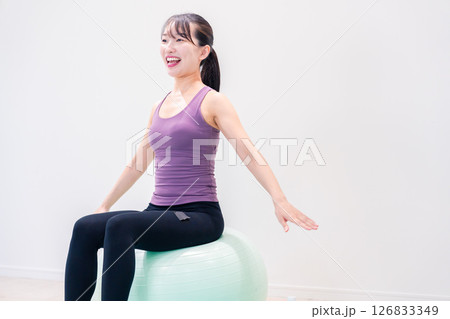 ジムでヨガコーチをするスポーティーな女性 126833349