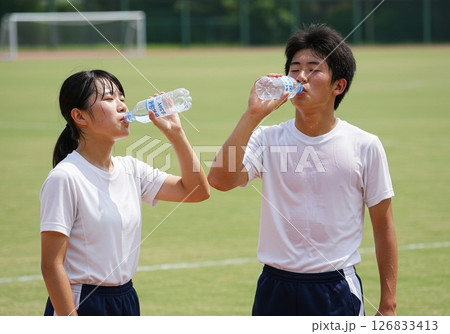 夏の部活動で給水する男女学生 126833413