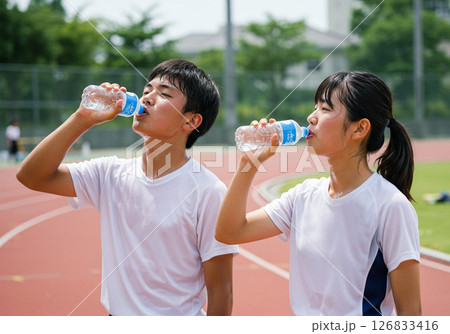夏の部活動で給水する男女学生 126833416