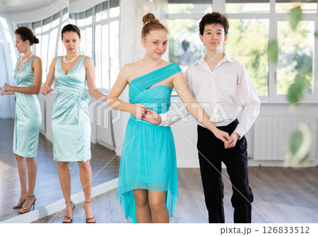 Girl and a boy in festive clothes learn to dance moresco under guidance of teacher Girl and a boy in festive clothes learn to dance moresco under guidance of teacher 126833512