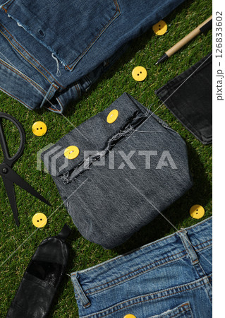 Denim bag and jeans on green background, top view 126833602