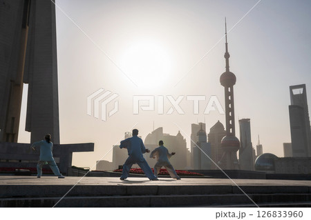 Chinese people practice Tai Chi at People Heroes Tower at sunrise, Shanghai 126833960