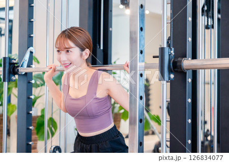 ジムで筋トレをするスポーティーな若い女性 ジムで筋トレをするスポーティーな若い女性 126834077