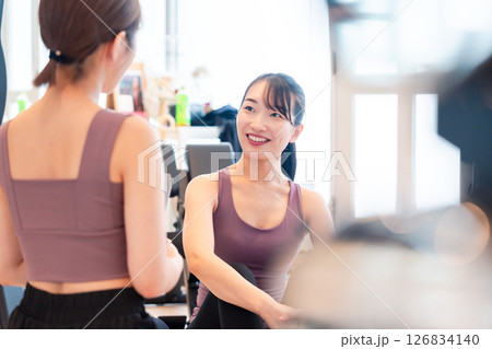 女性トレーナーからの指導を受けて筋トレをする女性 126834140