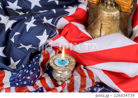 Lit candle in decorative holder next to American flags liberty bell symbolizes patriotism during US history Memorial Day Lit candle in decorative holder next to American flags liberty bell symbolizes patriotism during US history Memorial Day 126834739