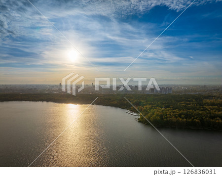 Autumn forest on lake shore at sunset and city on horizon, auerial view Autumn forest on lake shore at sunset and city on horizon, auerial view 126836031