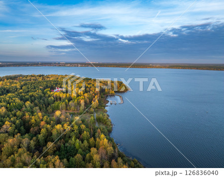 Autumn forest on lake shore at sunset and city on horizon, auerial view Autumn forest on lake shore at sunset and city on horizon, auerial view 126836040
