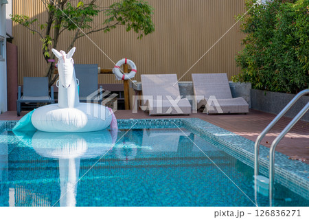 summer travel with lounge chair and swimming pool desk with tropical tree background 126836271