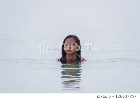 young asian woman enjoying swimming and smiling in shallow water of sea 126837757