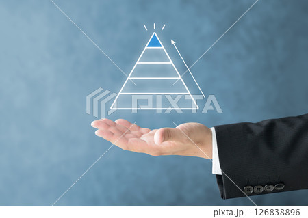 各階層に分かれたピラミッドを掲げるビジネスマンの手 各階層に分かれたピラミッドを掲げるビジネスマンの手 126838896