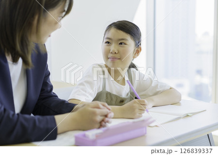 学習塾で勉強する小学生の女の子と先生　撮影協力：学校法人電波学園 東京電子専門学校 126839337