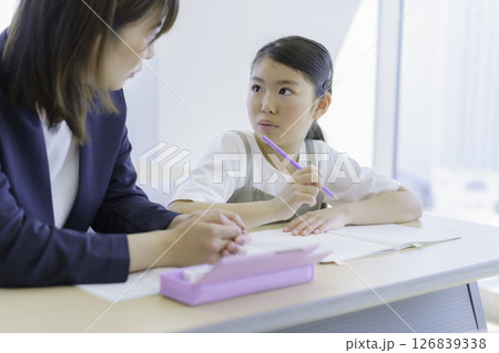 学習塾で勉強する小学生の女の子と先生　撮影協力：学校法人電波学園 東京電子専門学校 126839338