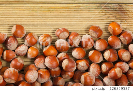 Unpeeled hazelnut on wooden surface closeup Unpeeled hazelnut on wooden surface closeup 126839587