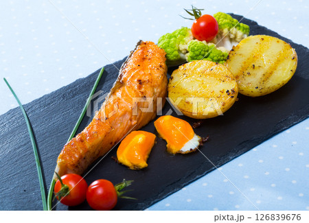 Grilled salmon with potatoes, fried egg yolk Grilled salmon with potatoes, fried egg yolk 126839676