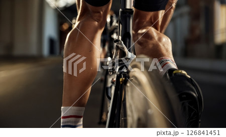 Close-Up of Racing Cyclists Legs Pedaling During Competition 126841451