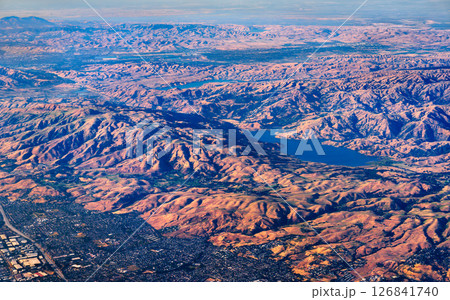 Sweeping aerial view of Calaveras Reservoir in California, surrounded by rolling hills and ridges of the Diablo Range with suburban areas visible on the edge of the frame Sweeping aerial view of Calaveras Reservoir in California, surrounded by rolling hills and ridges of the Diablo Range with suburban areas visible on the edge of the frame 126841740